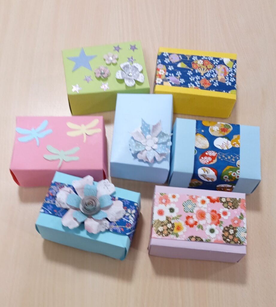 Seven decorative paper boxes made by group members