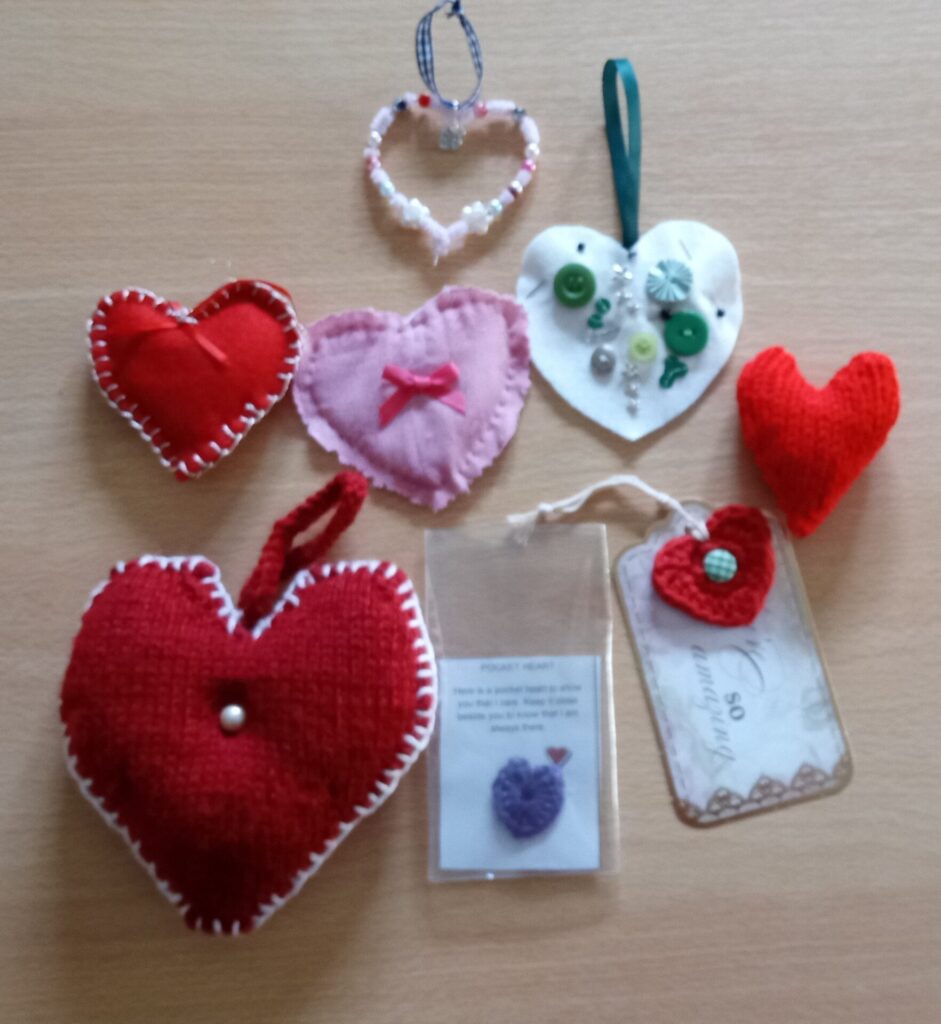 Busy Bee crafters made some felt hearts, with string holders at the top to hang or display. Some a re plain, some blanket-sititch edged and some have button or bow decorations.