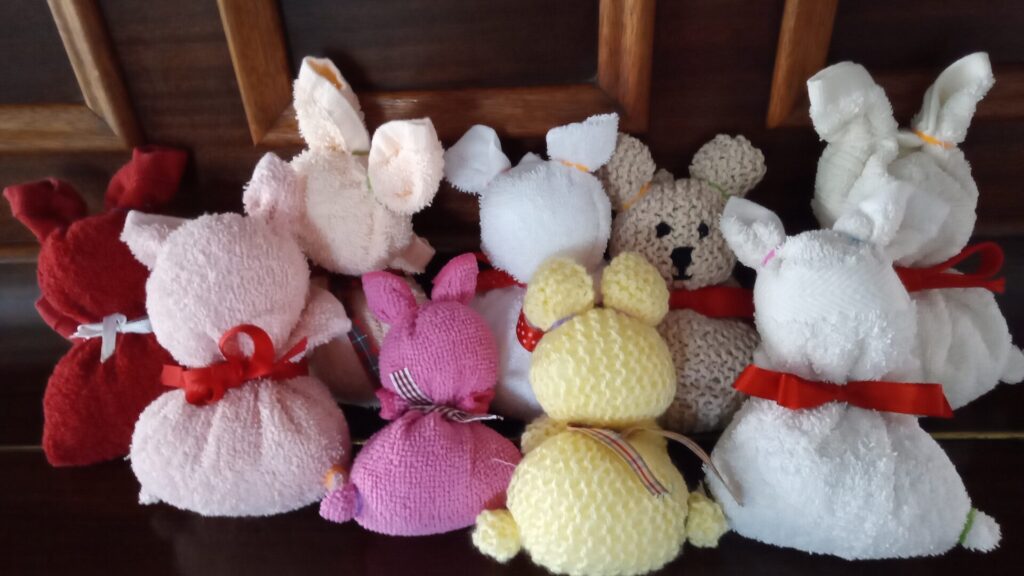 9 knitted rabbits made by members of the Busy Bees craft group for Easter 24. White, yellow, pink & red wools were used so very colourful.